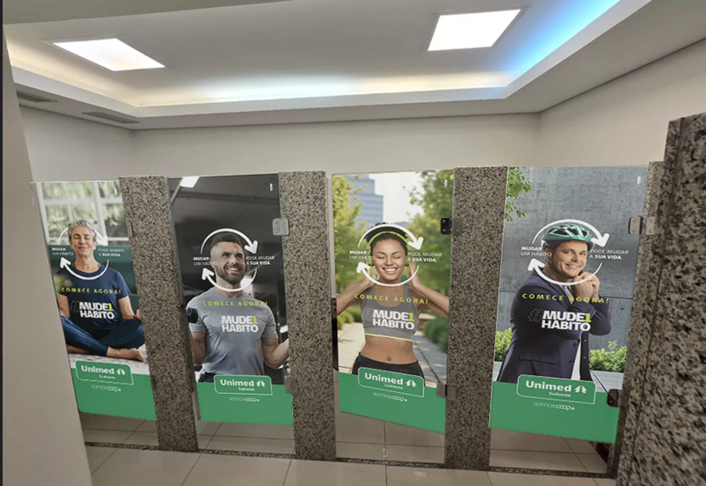 Adesivos #Mude1Hábito da Unimed Sudoeste instalados nas portas dos banheiros do Boulevard Shopping
